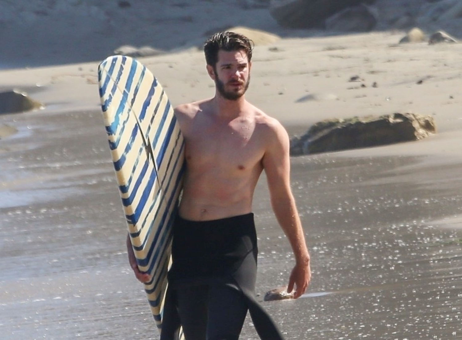 Andrew Garfield surfs on break