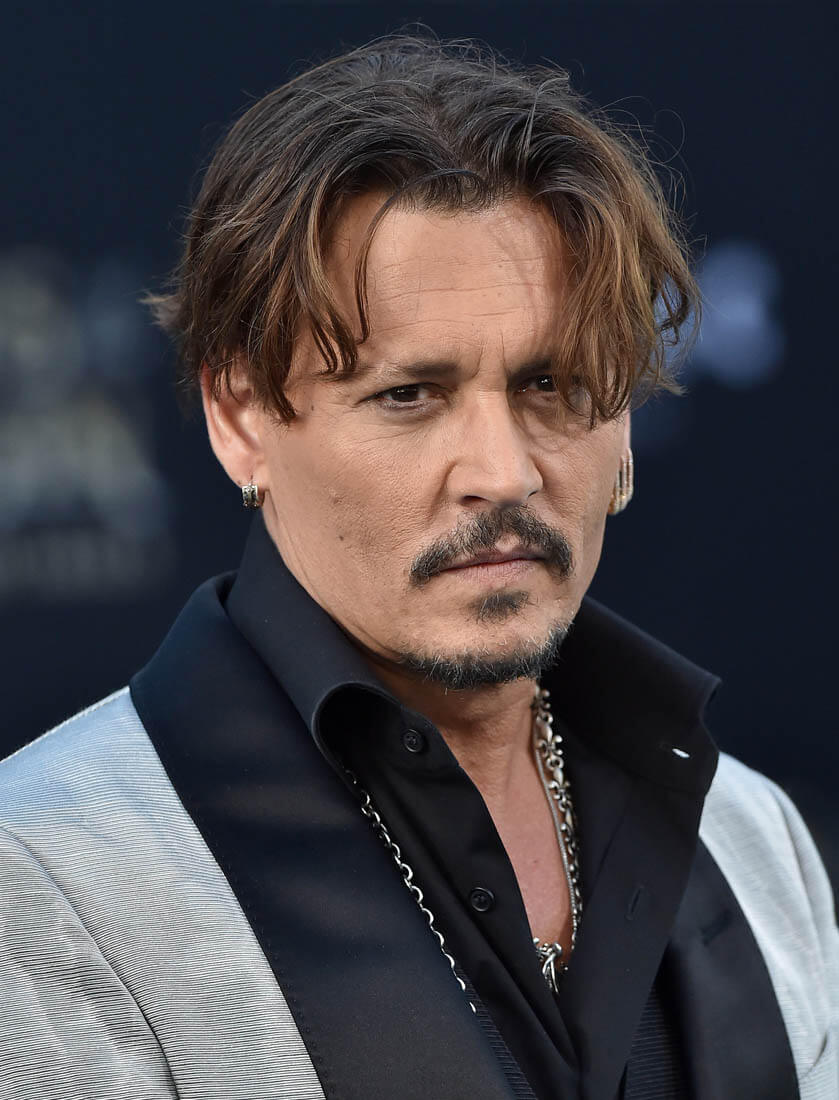 Johnny Depp and a pile of burning money in Pirates of the Caribbean 5